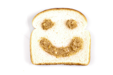 Fototapeta na wymiar Happy face peanut butter on white bread on a white background