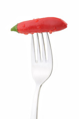 Red hot chili pepper on fork isolated on white background