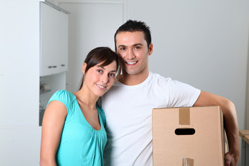 Young couple carrying boxes into new house