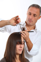 Hairdresser cutting woman's hair