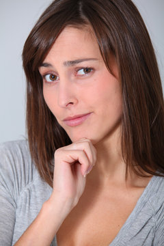 Young woman looking at camera with hand on chin