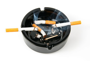 Ashtray with smoking cigarettes and butts