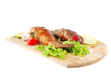 roasted sea fish on wood with tomatoes