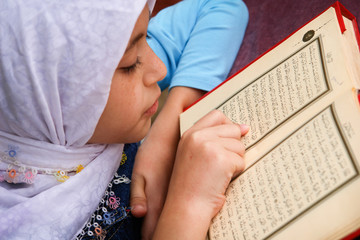 Little girl reads the holy Koran