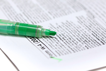 Close up shot of tax form and green marker