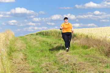 Naklejka na ściany i meble XXL-Model übergewichtige Frau beim Nordic Walking