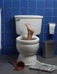 Foot reaches up through the seat from out of a toilet.