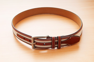 Leather belt on the wooden background