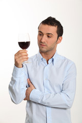 Young man on white background tasting red wine