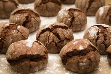 tray of freshly made chocolate cookies with icing sugar dusting