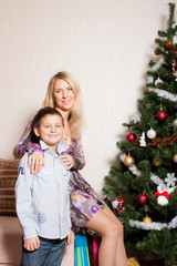 mother with a son near a fir-tree