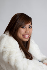 Happy smiling Asian woman in a fur coat