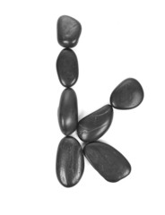 Letter 'K' made of stones isolated on white