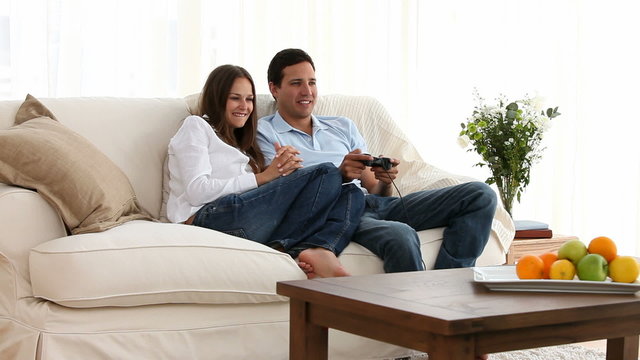 Man playing video games with his girlfriend on the sofa