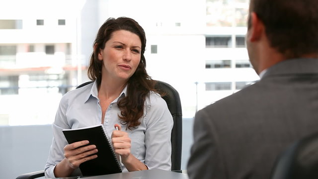 Businesswoman questioning a man during an interview