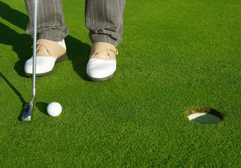 Golf green hole course man putting short ball