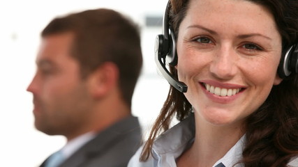 Happy representative with colleague working in a call center