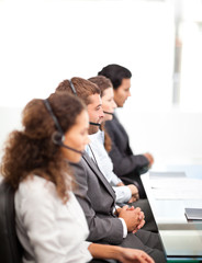Four businesspeople on the phone sitting at their desk