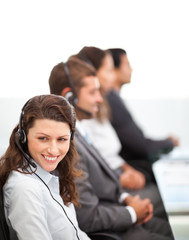 Pretty representative with her team working in a call center