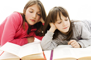 Two girls students studying on the floor.