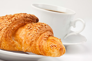Breakfast: coffee and croissant with sesame seeds