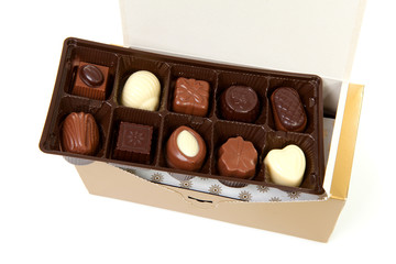 chocolate bonbons in box over white background