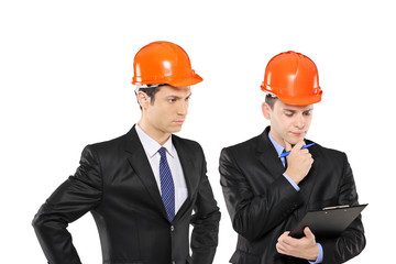 Two architects in black suit wearing helmet in thoughts