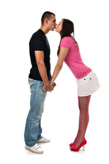 Young girl kisses her boyfriend while holding his hands isolated