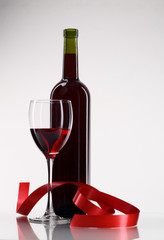 bottle with red wine and glass a decorative tape