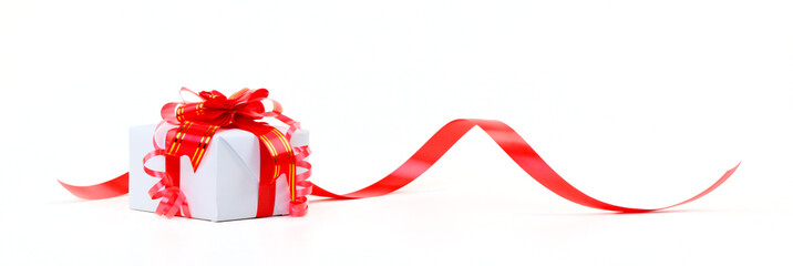 A white box tied with a red satin ribbon bow. A gift for Christm