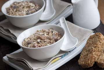 Muesli in a bowl with wheetabix and jug of milk