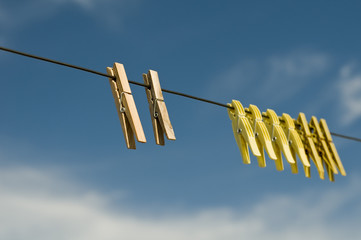 Wäscheklammern vor blauem Himmel