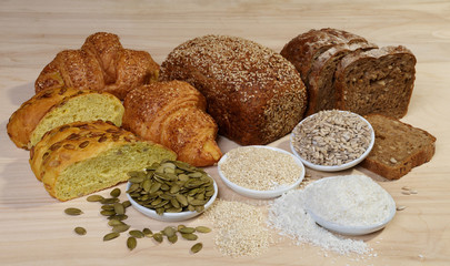 Naklejka premium Variety of bread and ingredients on wooden background
