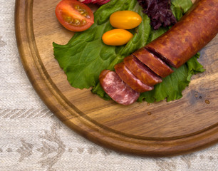 Breakfast close-up. Slices of sausage on the wooden plate with k