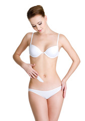 Fototapeta premium woman applying cosmetic cream on abdomen
