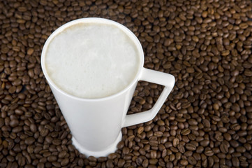 Cup of coffee with cream and beans background