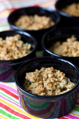 Home made apple crumble in black containers