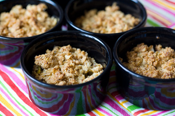Home made apple crumble in black containers