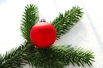 Red christmas ball on white snow