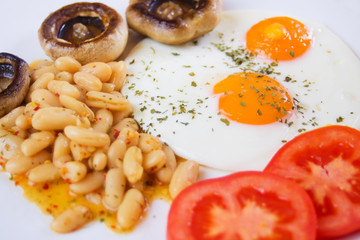 Fried eggs with beans and mushrooms