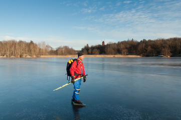 A male ice skater on a frozen lake