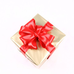 Gift in golden wrapping with red bow isolated on white