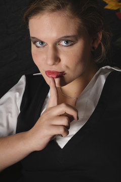 M&auml;dchen im Ledersessel hat ein Geheimnis macht 'pscht'-Geste