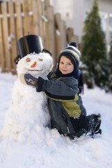 Kind umarmt einen Schneemann