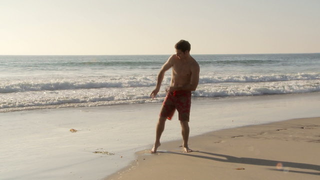 Young man being goofy and dancing at beach