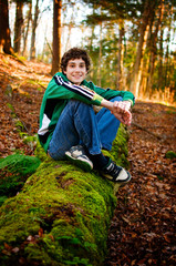 teen boy sitting in a forest