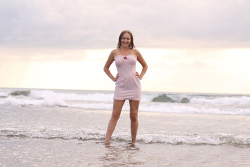 Fototapeta na wymiar young woman in pink dress at the beach