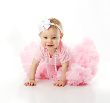 Baby girl wearing pettiskirt tutu and pearls crawling