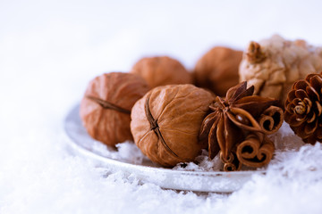 Nuts,spices and cones on a silver plate.Christmas decoration