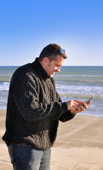 Homme en bord de mer et téléphone portable